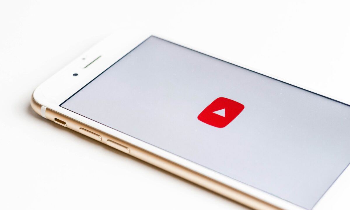 A mobile phone showing the logo of YouTube for blog about starting a real estate youtube channel.