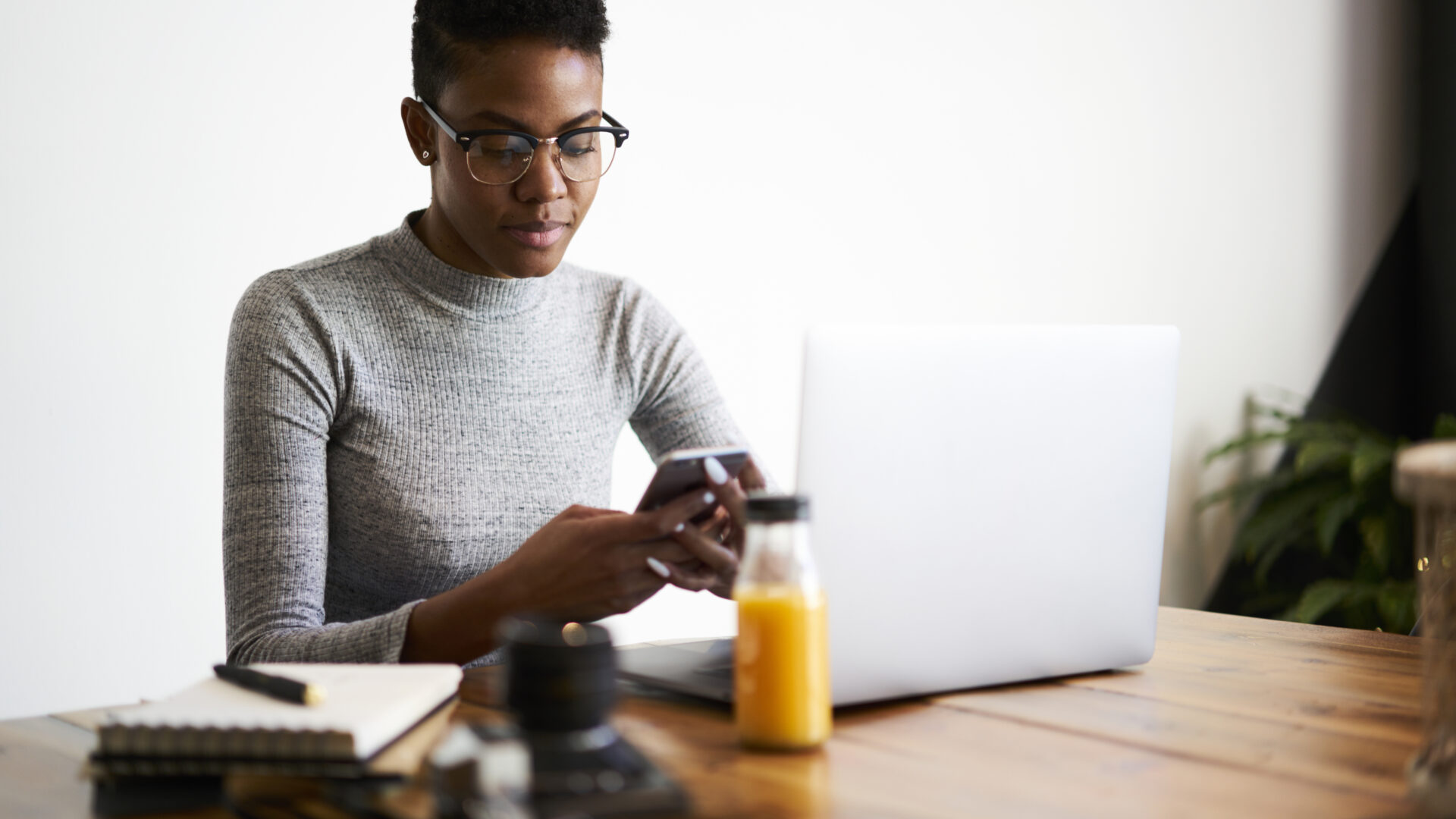 A customer checks her phone for a SMS real estate marketing message from a realtor.