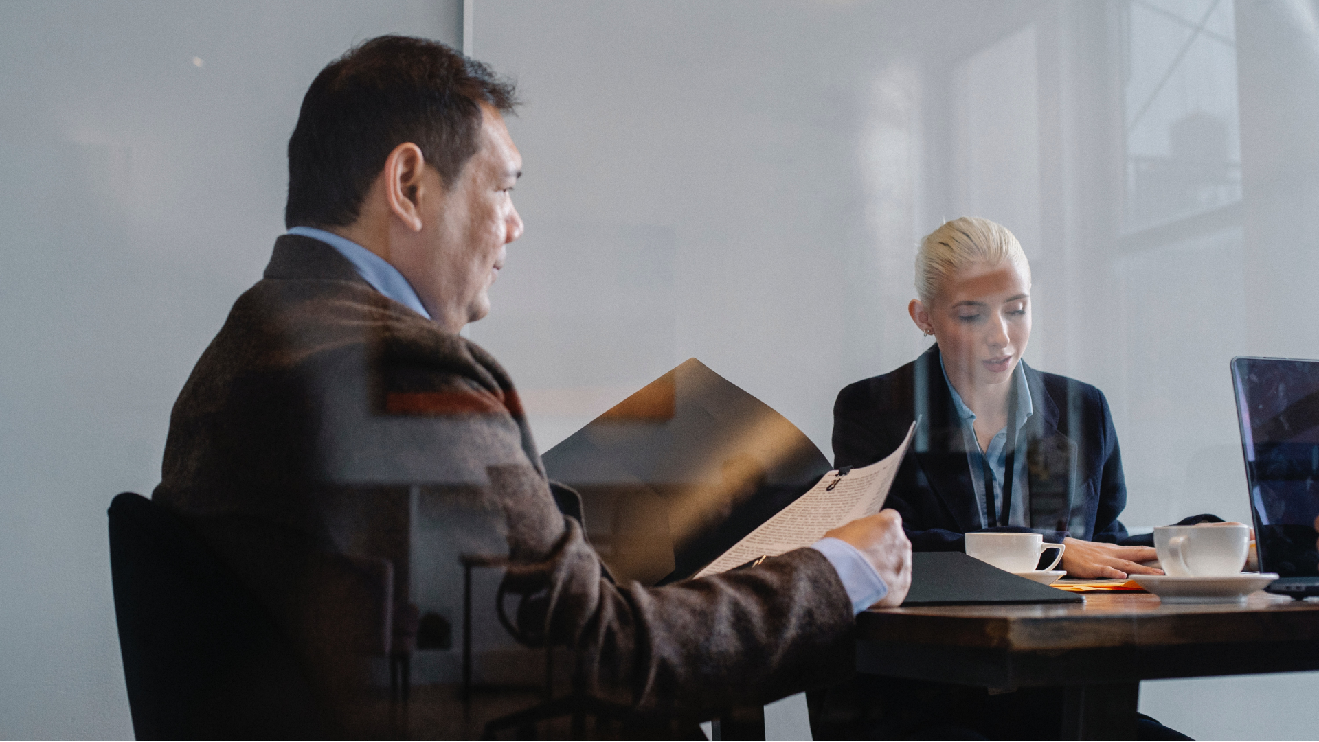 Business professionals sitting in conference room reading documents